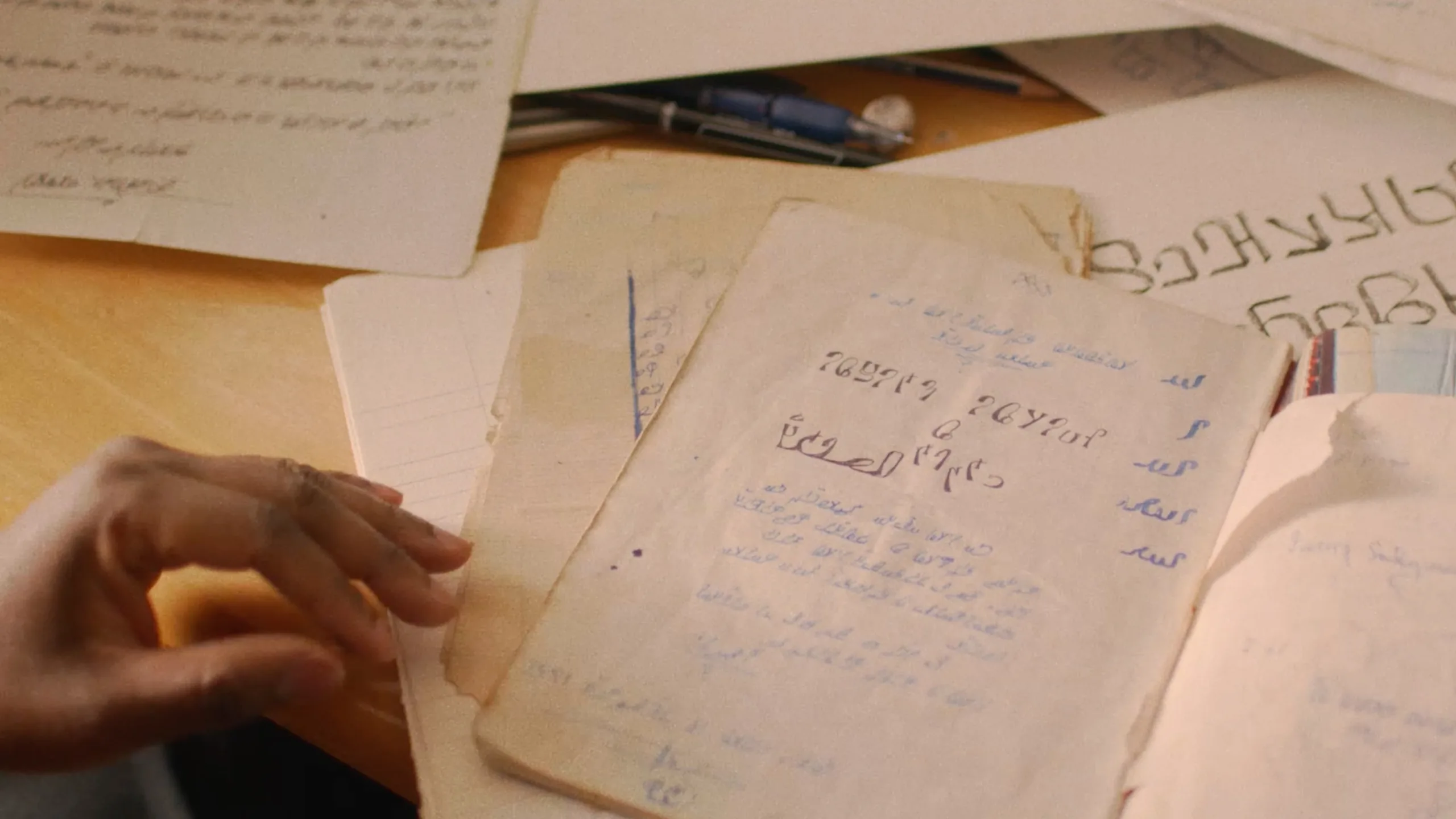 A hand holding a notebook with writing on it.