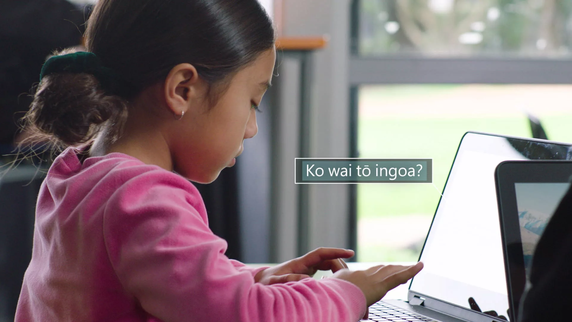 child at laptop with Maori language