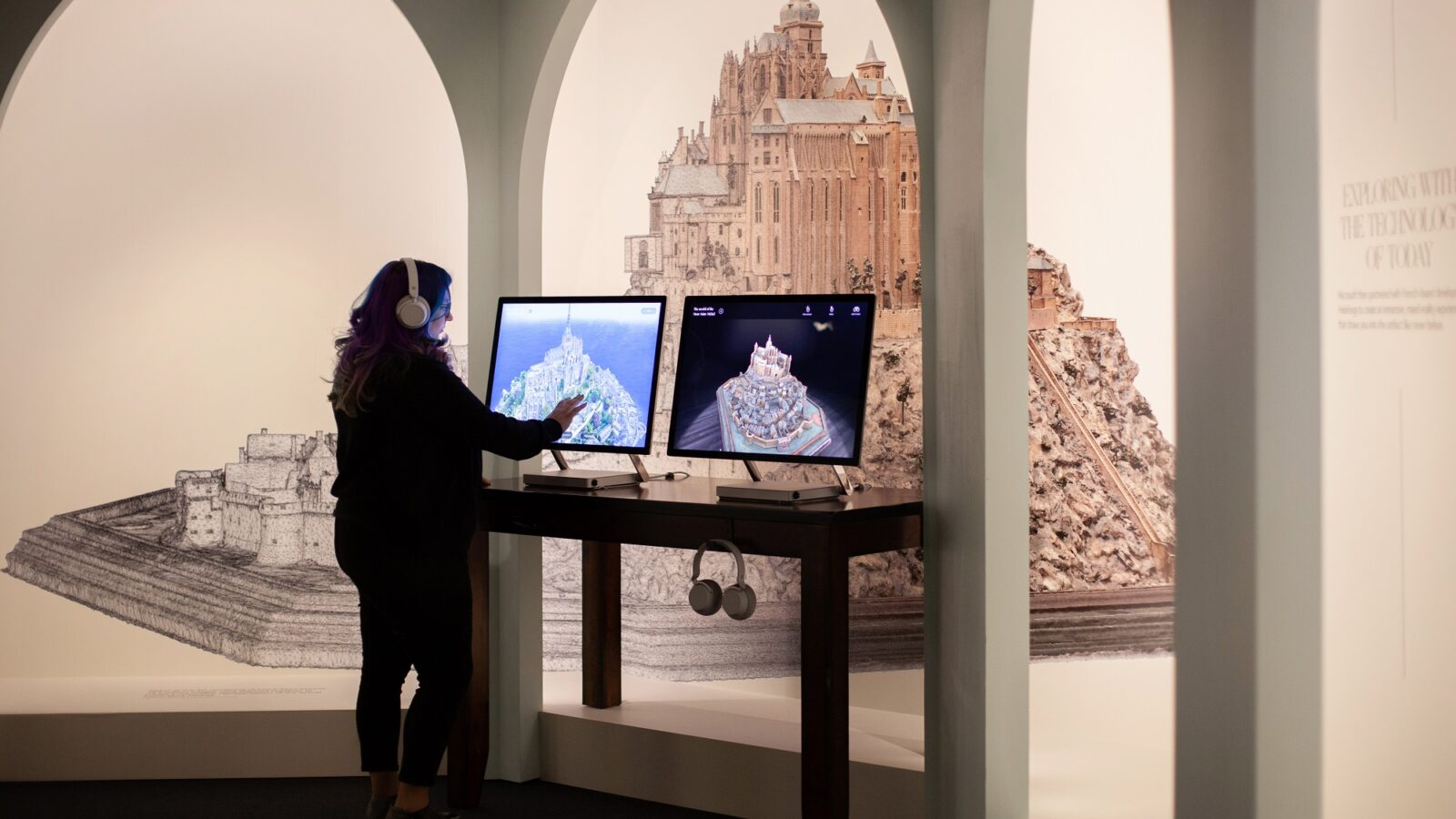 person viewing interactive touchscreen of Mont St Michel exhibit