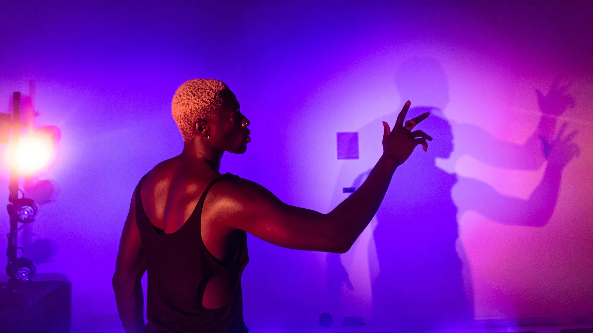 Moses Sumney creating shadows on wall