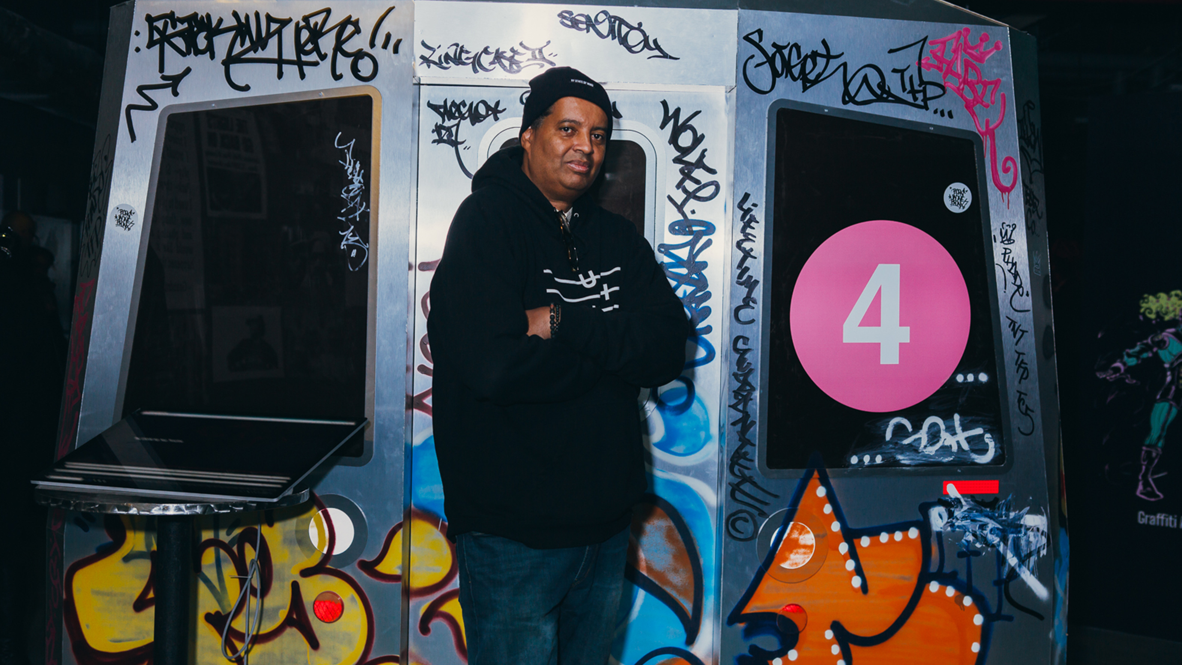 Executive Director of the Universal Hip Hop Museum, Rocky Bucano, stands in front of a life-sized replica of a subway train, housed with UHHM’s [R]Evolution of Hip Hop