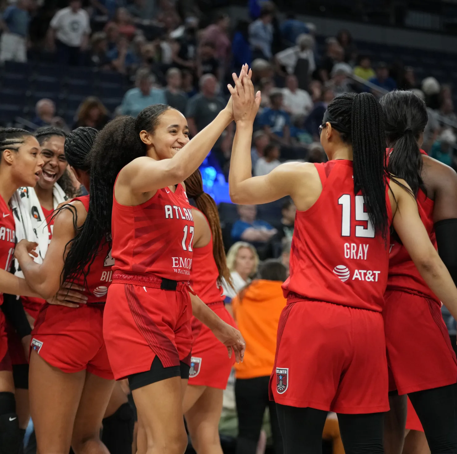 Two Atlanta Dream basketball players smile and high-five.