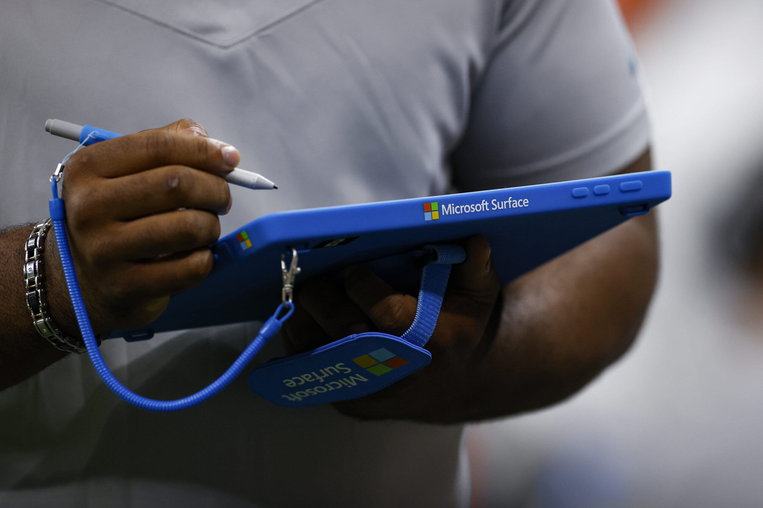 A man is holding a blue tablet with a pen.