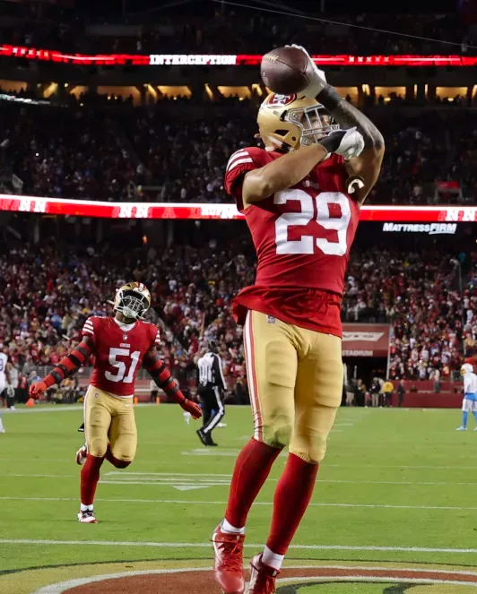 A san francisco 49ers football player catching a ball.