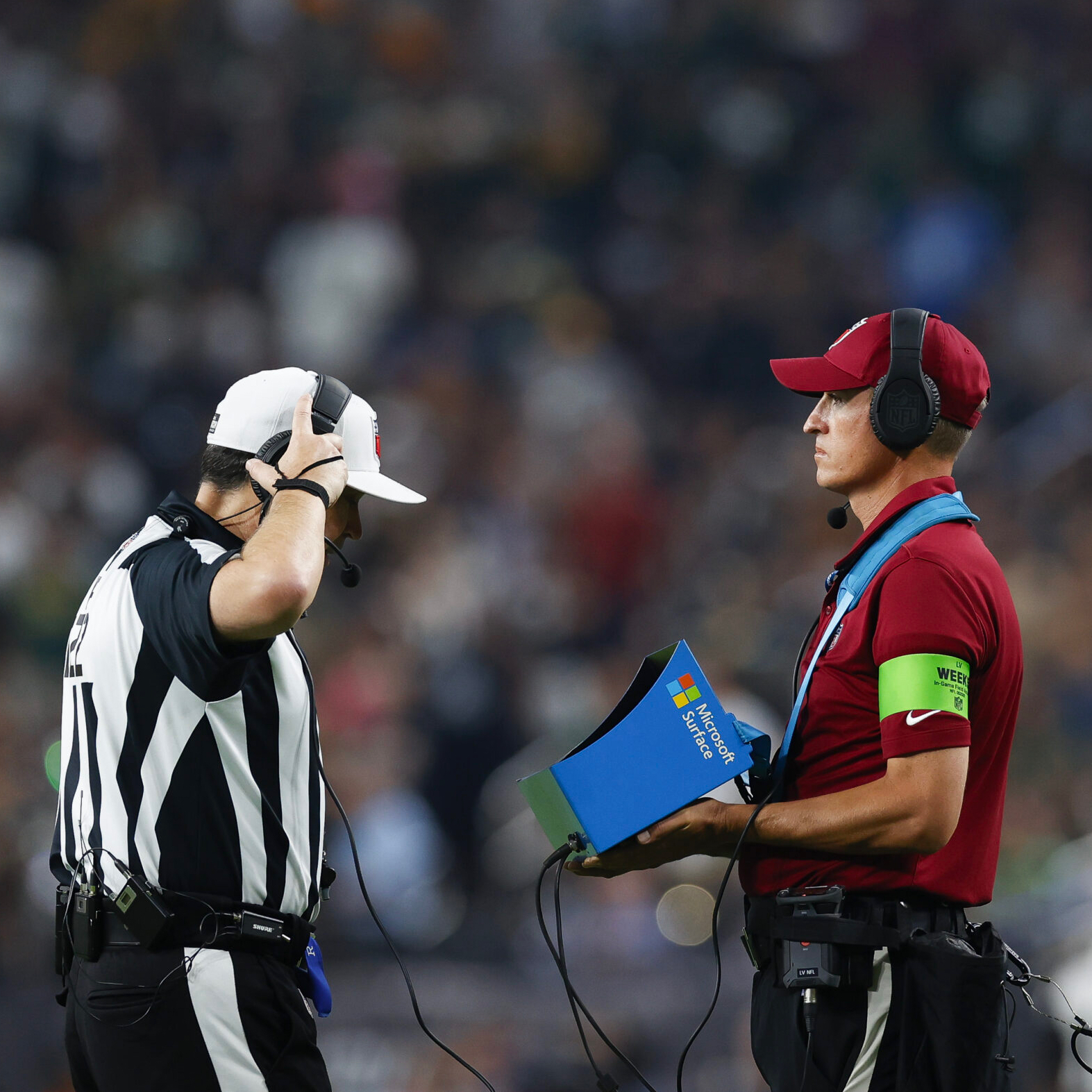 A referee is talking to a referee on the field.