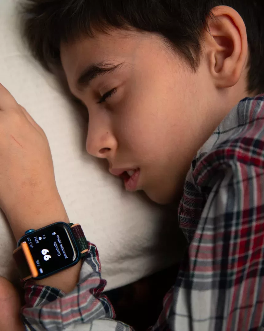 A young boy sleeping on his apple watch.