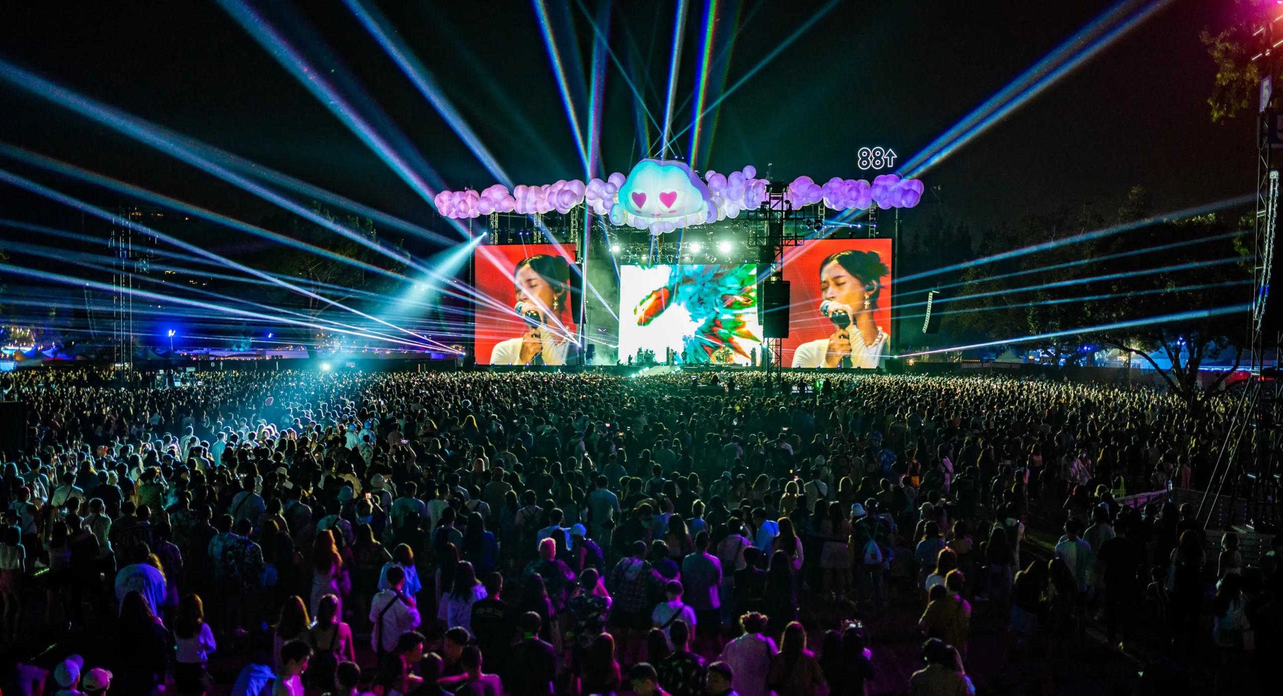 A night time view of the Head in the Clouds festival, showing Clo reacting to the artist on stage.