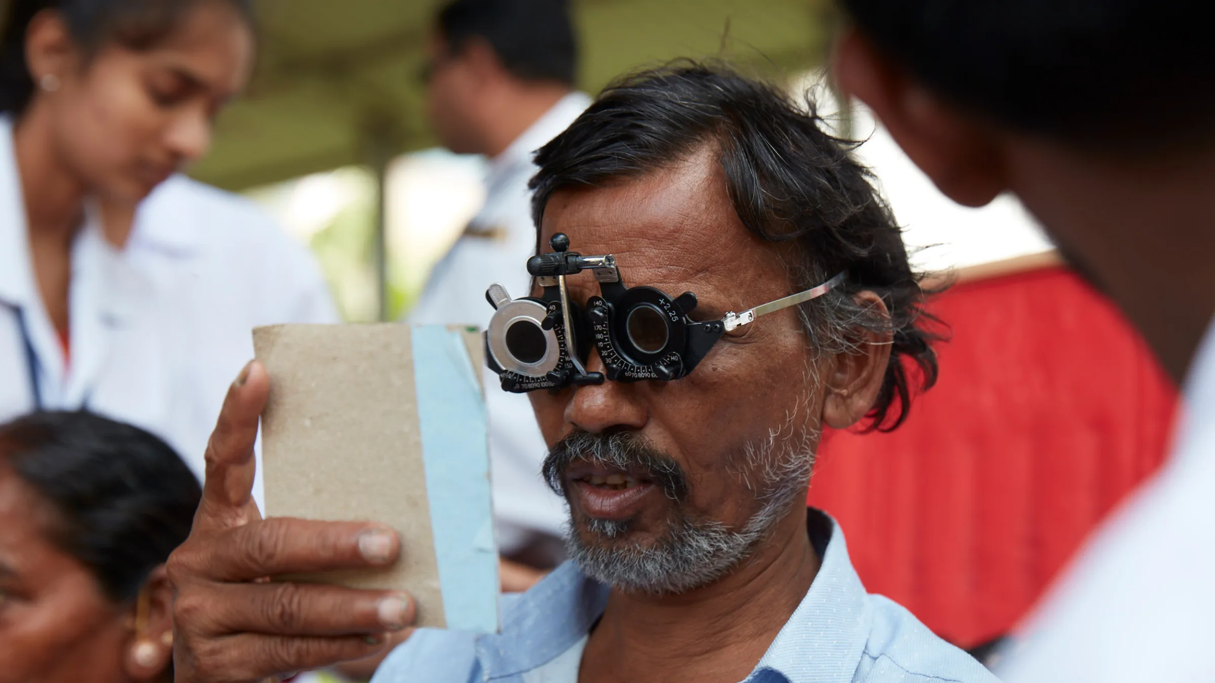 A man wearing glasses is looking at a paper.