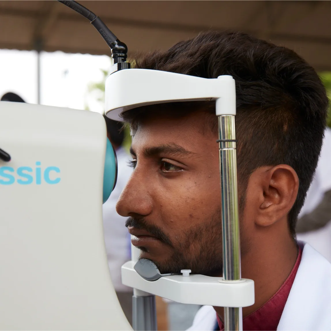 A man is looking at an eye exam machine.