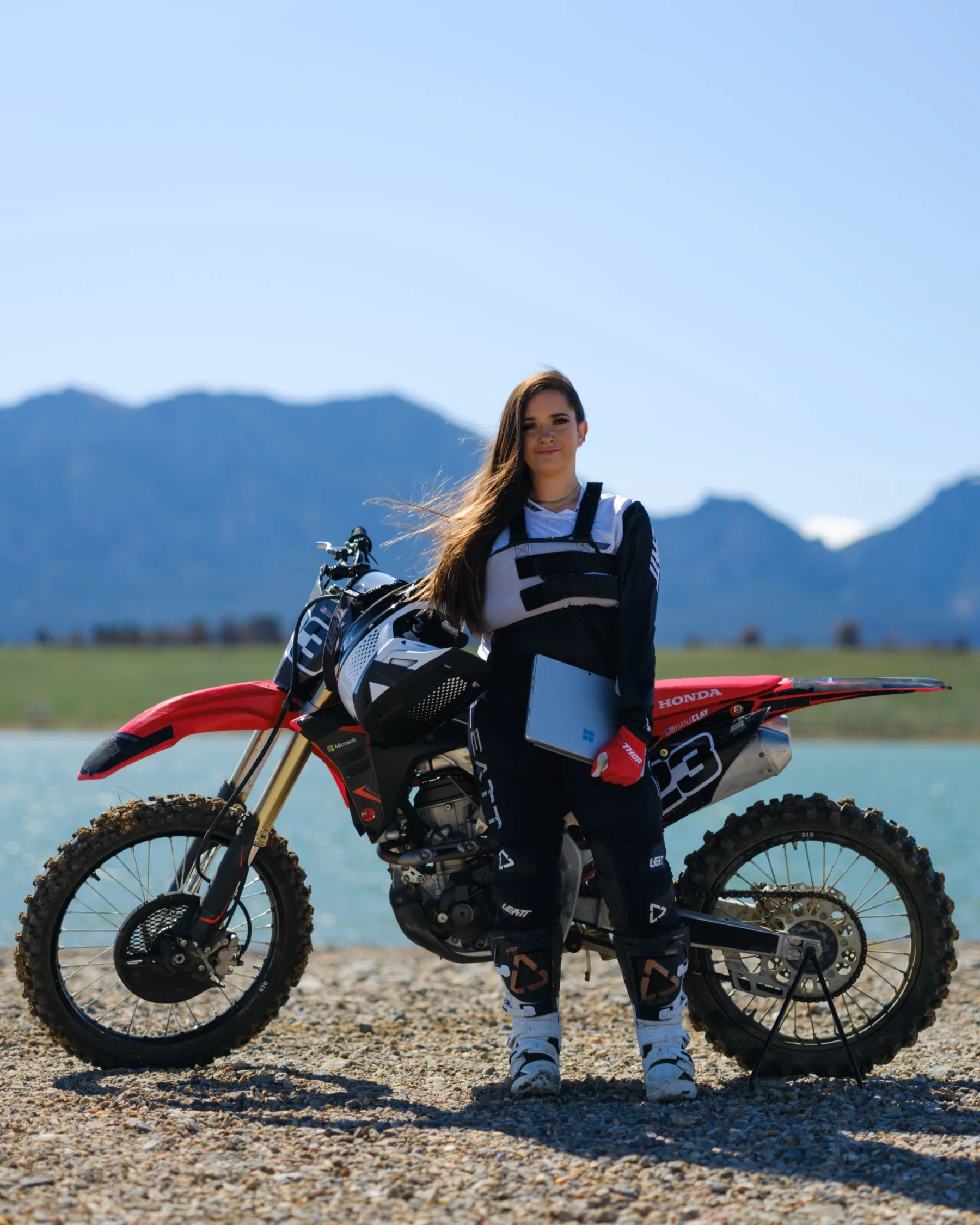Kiana Clay stands in front of motocross bike with Microsoft Surface in hand