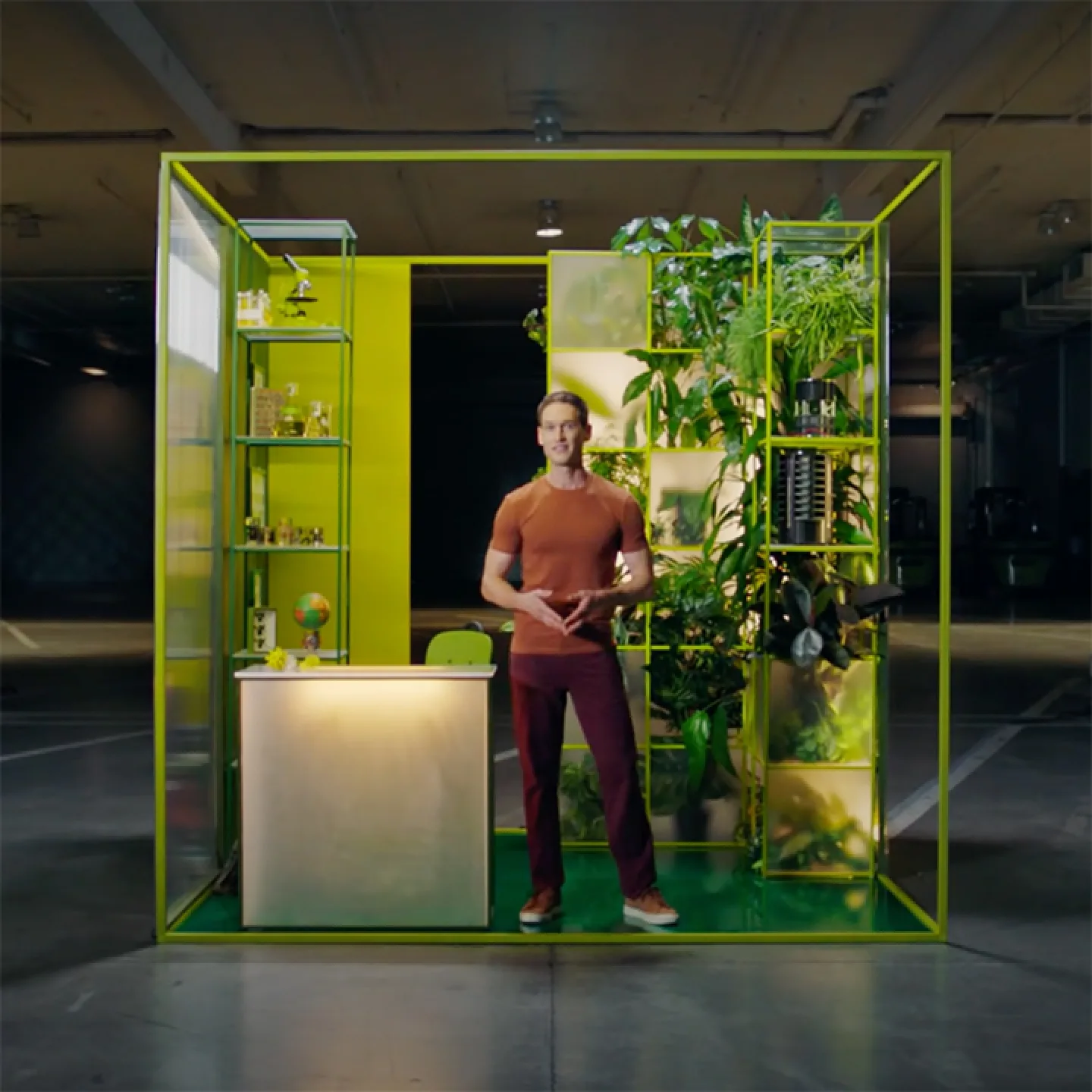 Thumbnail for a video, a man is seen in a greenhouse-like box in a studio setting.