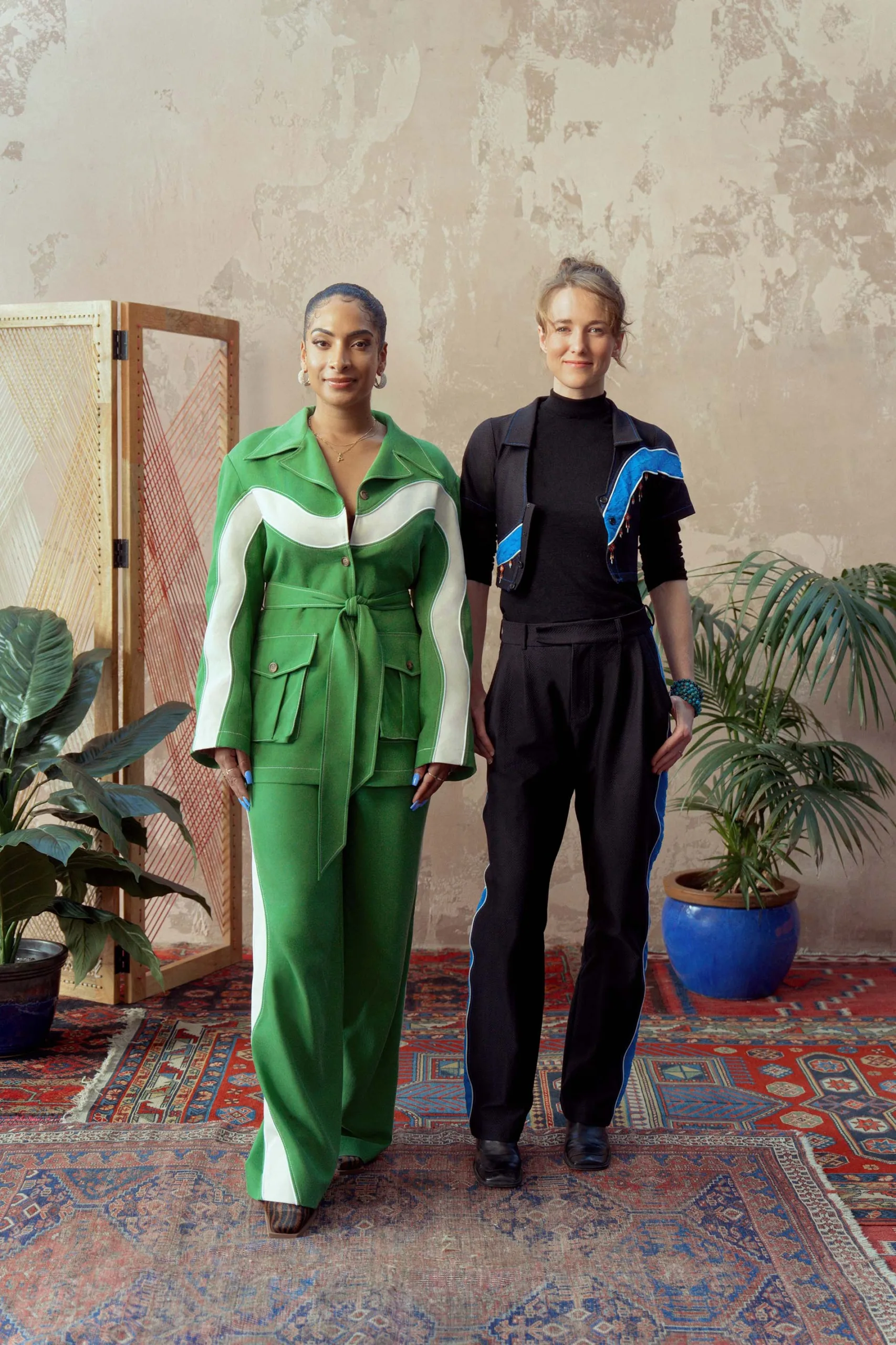 Two women standing next to each other in green and blue outfits.