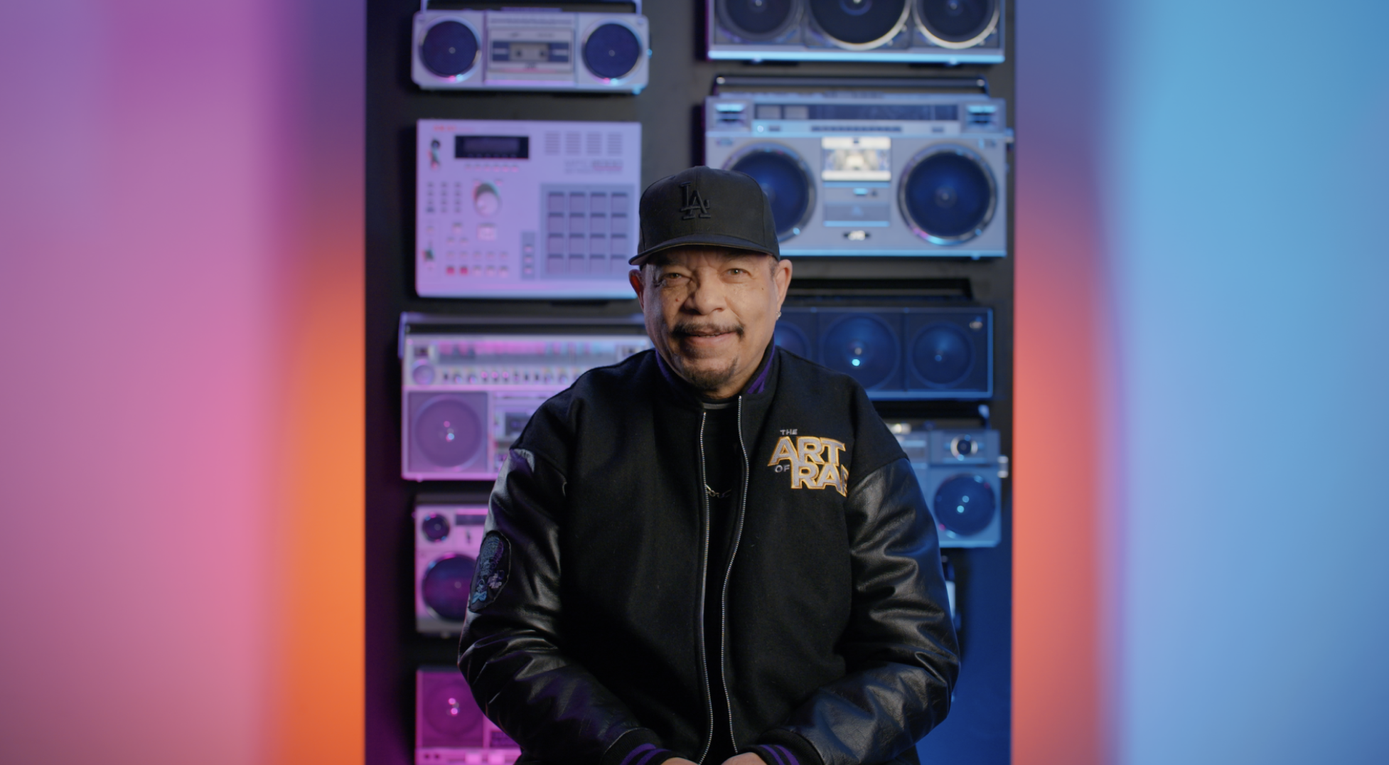 A man in a black jacket standing in front of a stereo.