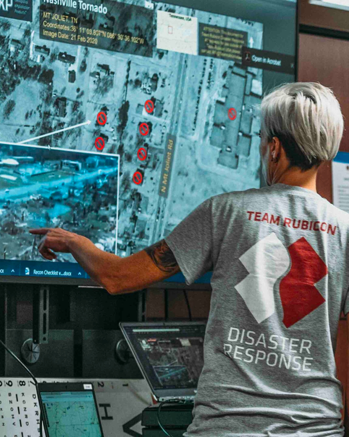 A woman is pointing at a computer screen.