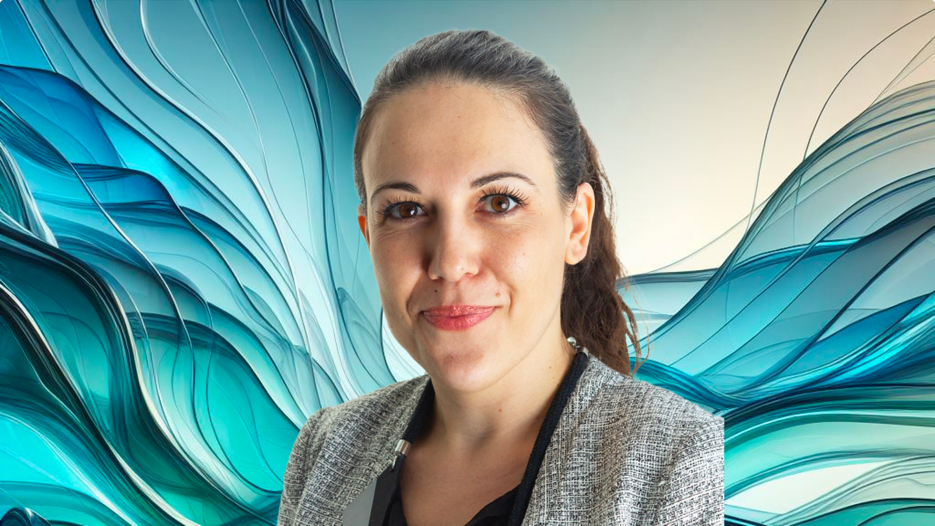 A woman is smiling in front of a blue background.