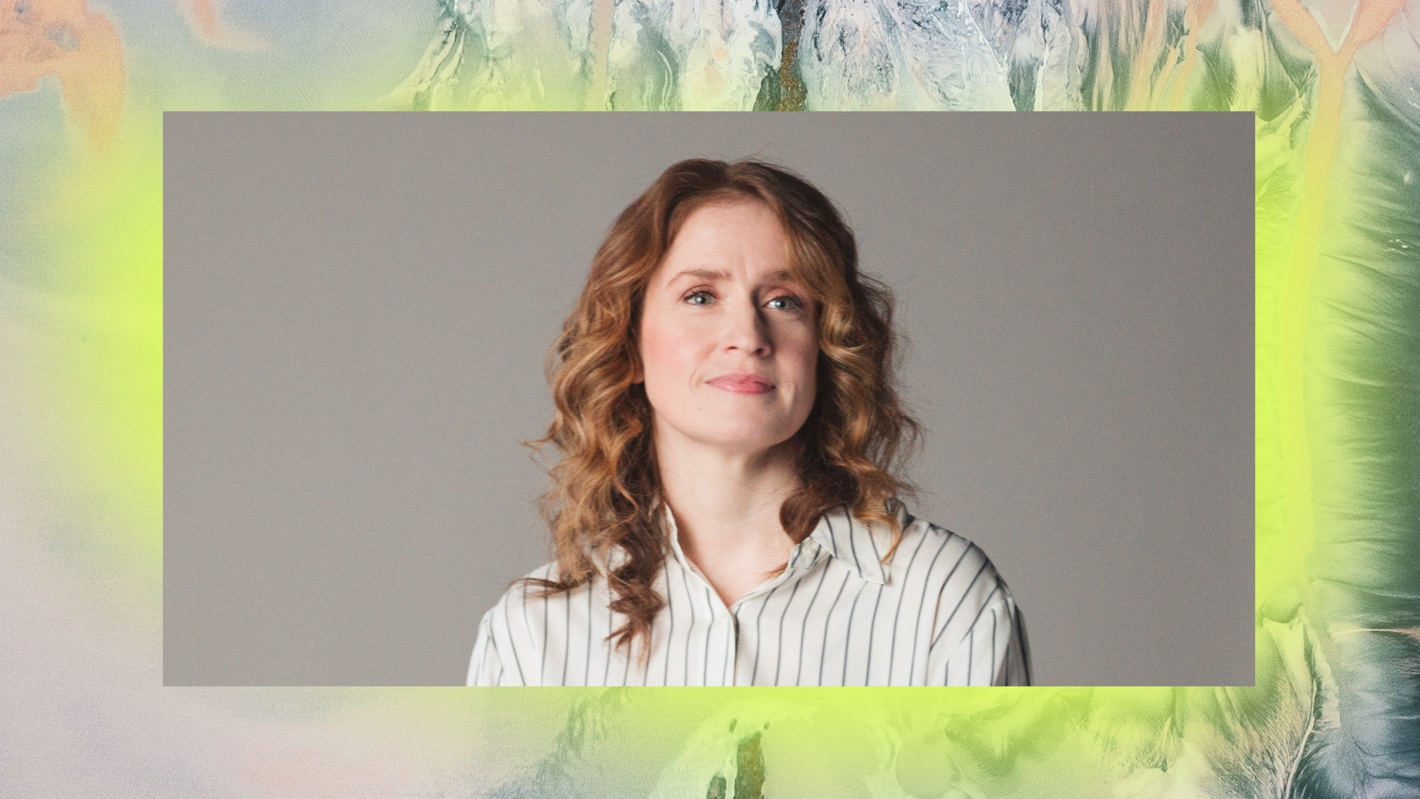 A woman with medium-length curly hair and a striped shirt, smiling subtly against a colorful abstract background.