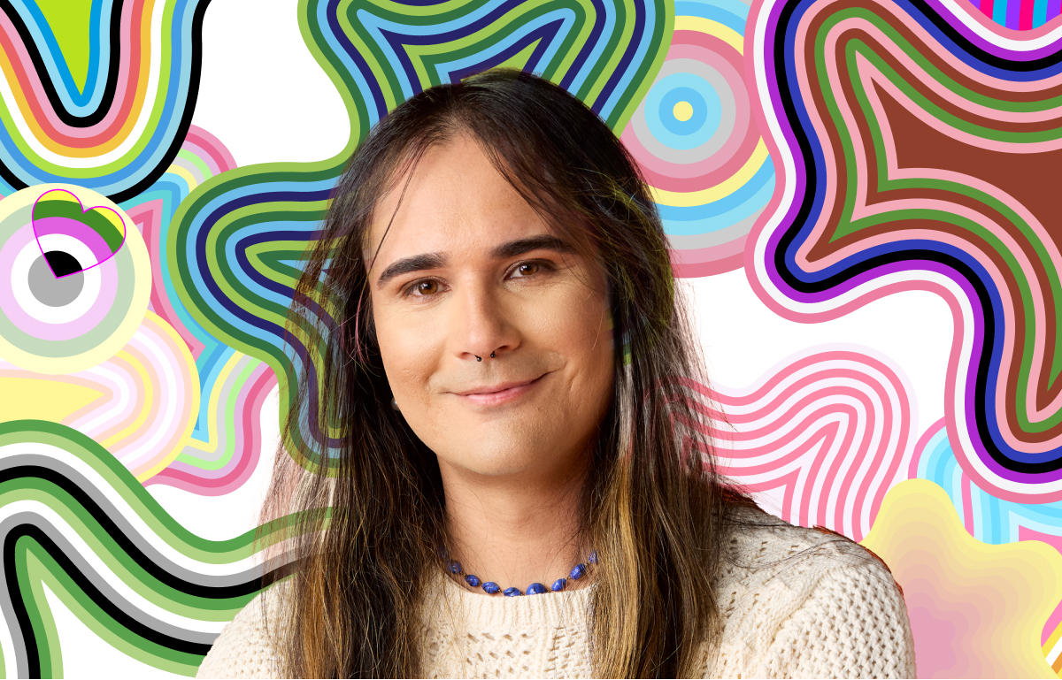 A person with long hair, wearing a knitted sweater and a beaded necklace, stands in front of a vibrant, colorful abstract background.