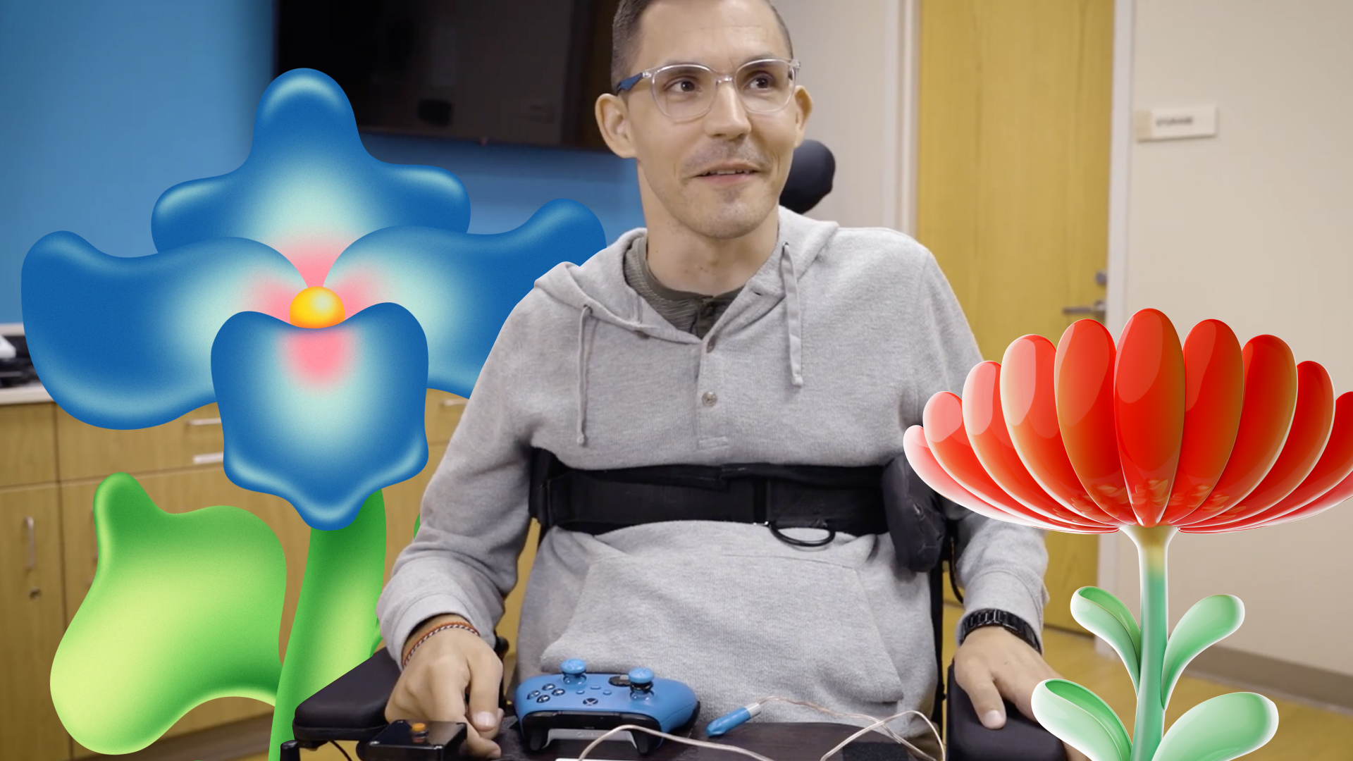 Man in a wheelchair at a desk, holding a game controller, with colorful, abstract flower graphics overlaid on the image.