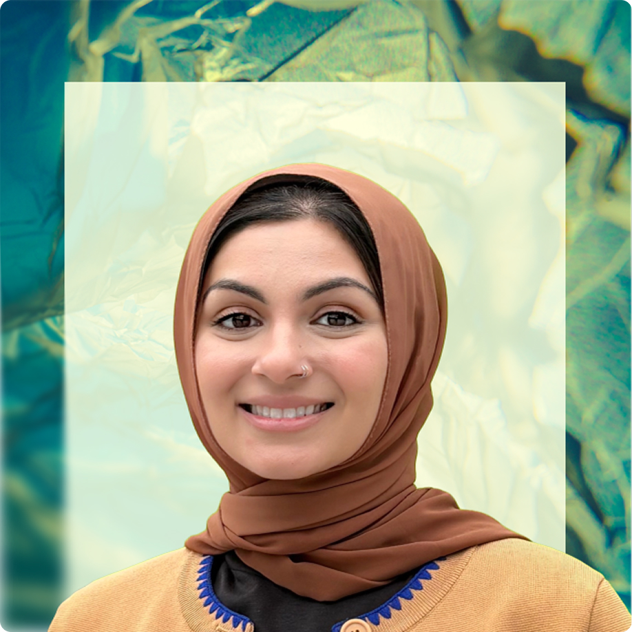 A smiling woman wearing a brown hijab and a tan cardigan with blue embroidery, photographed against a teal and cream abstract background.