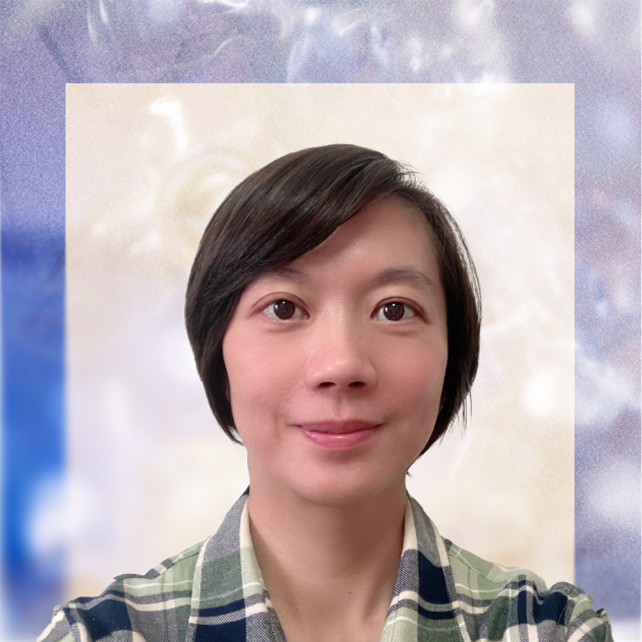 A person with short dark hair, wearing a green and gray plaid shirt, smiles at the camera against a light and blue abstract background.