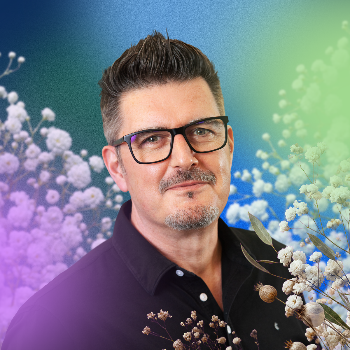 Julian Duffy, a man with short dark hair, a goatee, and black-framed glasses, wearing a dark polo shirt, posed against a colorful gradient background with white and